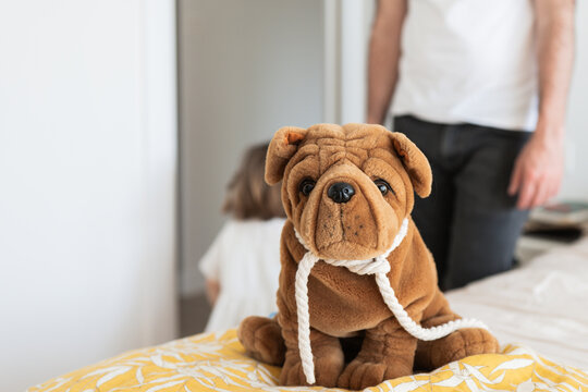 Stuffed dog toy with family in soft focus background