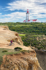 nice active woman cycling with her electric mountain bike on the cliffs of Cabo Espichel near Sesimbra, Portugal - 792607215