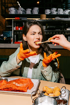 Woman Enjoying Spicy Chicken Wings at Outdoor Eatery