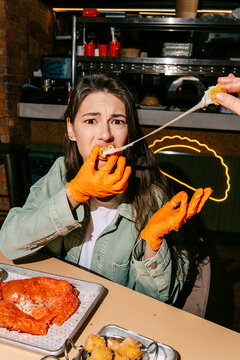 Woman enjoying a gooey cheburek in a casual dining setting