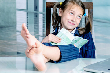 Money may buy happiness concept. Happy beautiful  child business girl working in the office. Horizontal image.