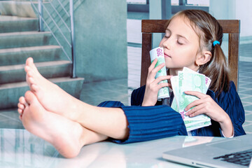 Money may buy happiness concept. Portrait of happy child business girl working inthe office. - 792608497