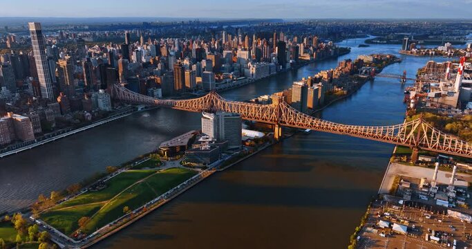 Going down above the East River with the Queensboro Bridge over it. Vast scenery of New York at sunset.