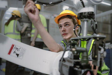 Computer science development engineer working on maintenance robotic arm connection and control. Technician training learning electronic robot innovation engineering at AI automation research center.