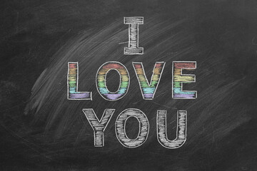 I love you. Inscription in chalk on the blackboard with rainbow colors. LGBT, LGBTQIA rights and gender equality concept. Pride month. Declaration of love, acceptance of feelings, giving love.