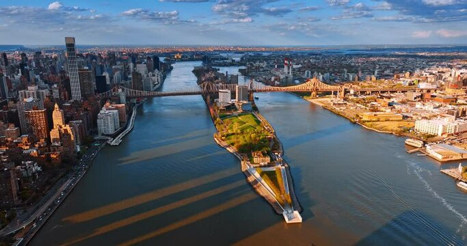 View of Queensboro Bridge connecting Long Island and Queens in New York. Sunset scenery of East River from drone.