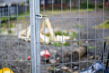 Vacant land fenced off for residential house building. Rubbish dumped inside the fenced area. Auckland.