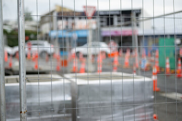 Building materials fenced off on a construction site. Selective focus on the metal fence. Auckland.