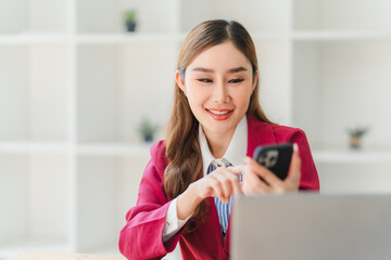 Portrait of a happy beautiful Asian businesswoman. Working with a tablet in a company office