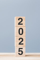 wooden cube block with 2025 text on table background. Resolution, plan, review, goal, start and New...