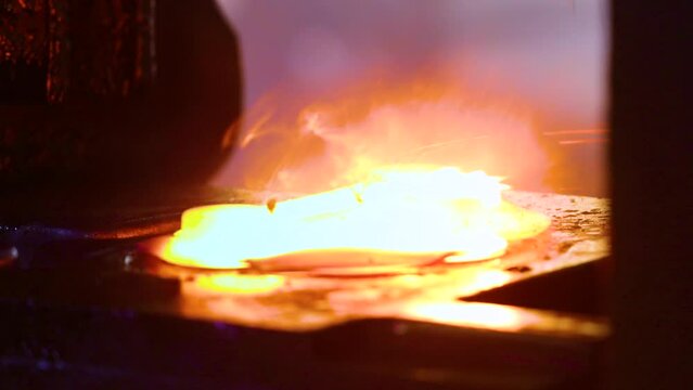 forging industry. hot drop press forging. metal piece shaping. automatic drop hammer giving it a tool shape. metal hit by a hammer on a mould cast machine tool component part. forging factory