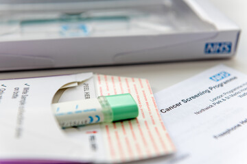 London. UK- 04.17.2024. A sample holder with a sealed bowel cancer test sample ready to go into the return envelope to be sent off for testing. - obrazy, fototapety, plakaty