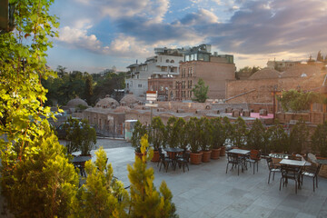 Landscape of historical Tbilisi with restaurant and sulfur baths on the background of sunset sky - obrazy, fototapety, plakaty