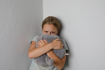 Sad young girl crying and looking at camera at home