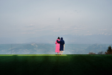 Unrecognizable couple hugging and admiring nature in daylight