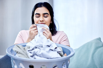 Fresh, laundry and woman smell clothes on sofa for washing, hygiene and spring cleaning in...
