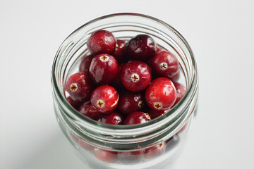 Cranberry closeup in a simple glass jar. White background