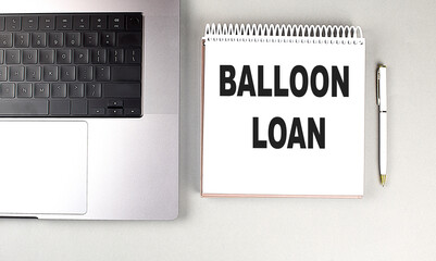 BALLOON LOAN text on notebook with laptop and pen