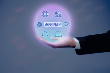 Webinar. Businessman holding virtual icons on color background, closeup