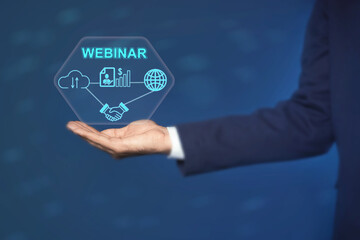 Webinar. Businessman holding virtual scheme with icons on blue background, closeup