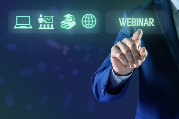 Webinar. Businessman using virtual screen with icons on blue background, closeup