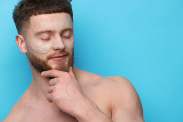 Naklejka premium Handsome man with facial mask on his face against light blue background