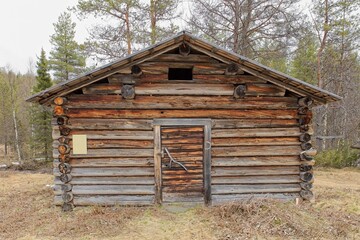 Old log cabin in cloudy spring weather at Riutukka Log Floating Museum, Salla, Lapland, Finland.