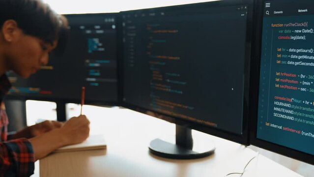 Slow motion back end software developer engineer for computer programming working together on debugging writing computing code, solving complex algorithms display on monitor in office. Burgeoning