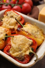 Delicious stuffed peppers in baking dish on table, closeup