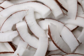 Fresh coconut pieces as background, closeup view