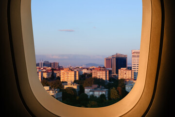 Fototapeta na wymiar Beautiful city with buildings, view through airplane window during flight