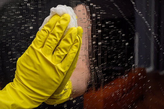 Myć lustro w żółtej gumowej rękawicy