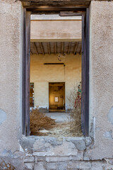 Symmetrical tunnel of door frames in abandoned buildings in Al Jazirah Al Hamra haunted town in Ras...