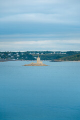 islet with a lighthouse in the middle of a bay in Brittany, France.