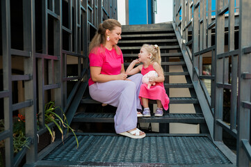 Fototapeta premium Mother holds and have fun her child with hearing aids and cochlear implants summer outdoor . Deaf and health concept. Diversity and Inclusion and people with disability concept. Copy space