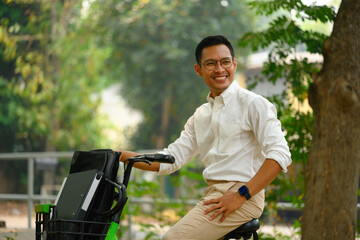 Shot of young handsome businessman riding bicycle to work in morning - 792679803