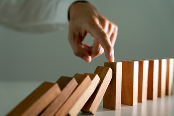 insurance with hands protect domino. Businessman hands stop dominoes falling in business crisis....