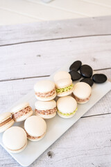 Macaroons of different colors with sprigs of mint on a white background.
