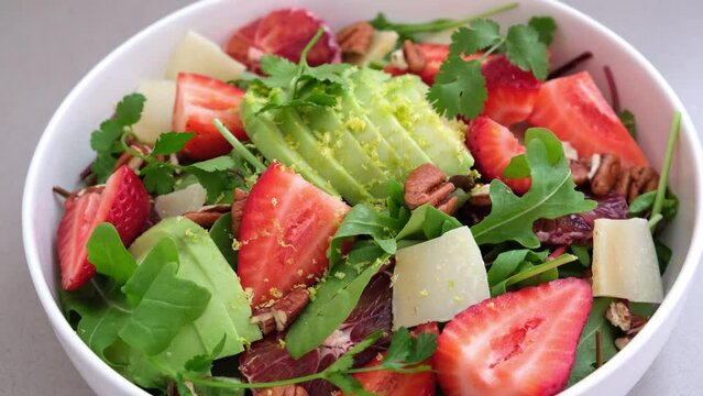 Summer green salad with strawberries, avocado, parmesan and pecans.