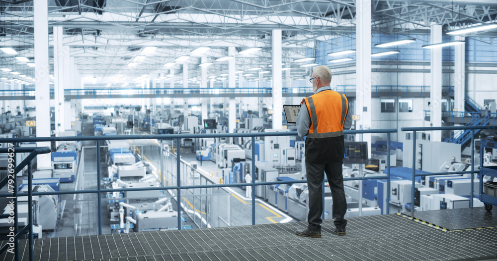 Poster industrial engineer working at a technology factory. middle aged male using laptop computer at work,