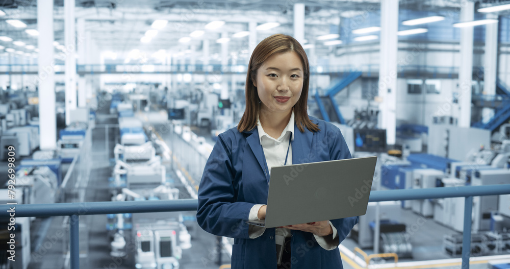 Poster portrait of a beatiful electronics manufacture engineer smiling, looking at camera. young japanese f