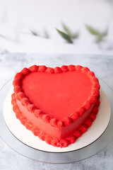 Beautiful cake in the shape of a red heart. Vertical photo.