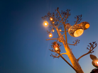 Decorative white handmade calabash gourd water pumpkin lamp hanging against dark sky background,...