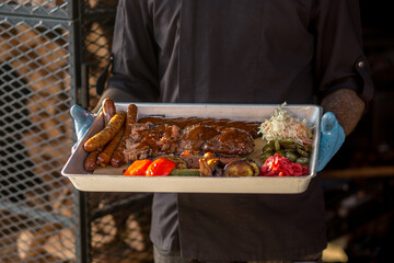 Succulent BBQ feast, highlighted by tender ribs and juicy sausages, served with vibrant, fresh...
