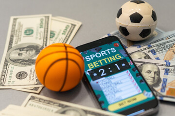Sports betting website in a mobile phone screen, ball, money - 792729269