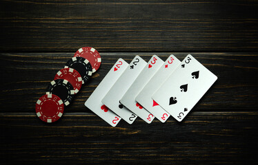 Chips and playing cards with a winning combination of full house or full boat on a dark vintage...