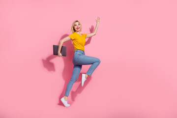 Fototapeta na wymiar Full length photo of funky funny lady dressed yellow t-shirt jumping hurying holding modern gadget isolated pink color background