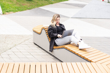 Young woman with laptop outside - 792731883