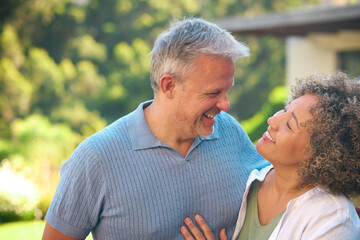 Obraz premium Portrait Of Laughing And Smiling Mature Multi-Racial Couple Standing Outdoors In Countryside
