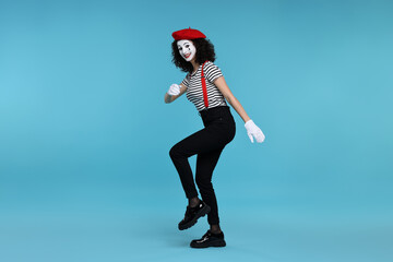 Funny mime with beret posing on light blue background